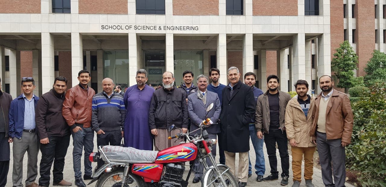 LUMS faculty and participants gathered with a Jolta electric motorcycle